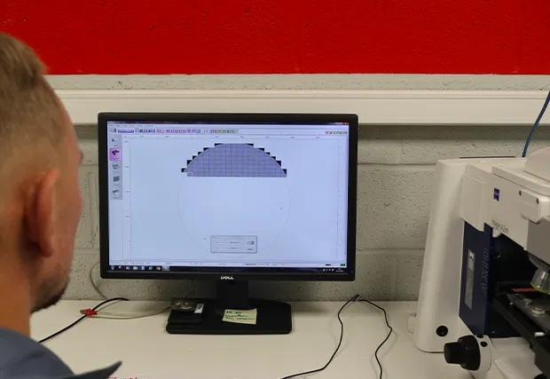 Technician analysing particles under a microscope